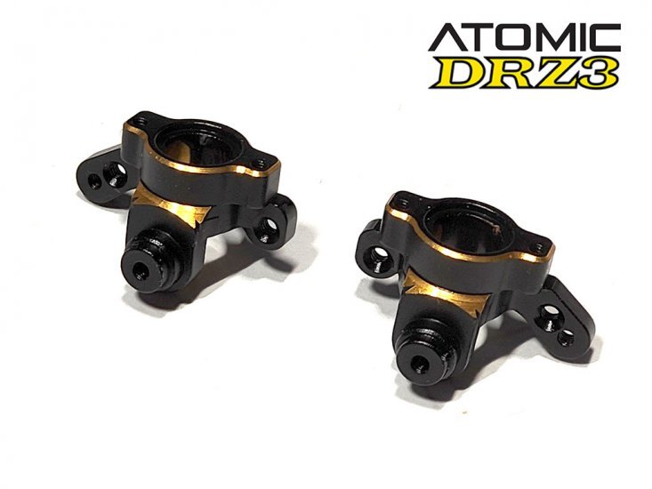DRZ3-UP08 De afbeelding toont twee zwarte aluminium fusees met gouden accenten. Ze hebben een complexe vorm met diverse gaten en bevestigingspunten.