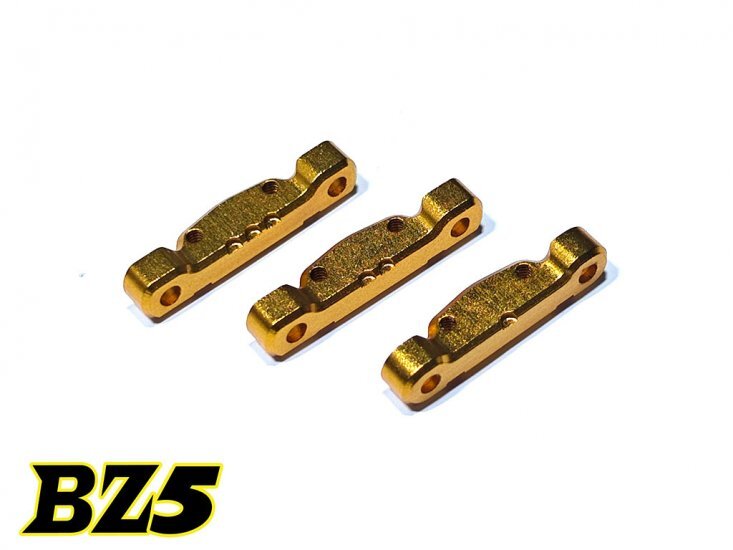 BZ5-UP07 De foto toont drie goudkleurige, metalen onderdelen met een langwerpige vorm en meerdere gaten. Ze lijken identiek en zijn netjes naast elkaar gerangschikt op een witte achtergrond.