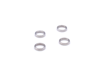 De foto toont vier zilverkleurige ringen, vermoedelijk spacers. Ze liggen verspreid op een witte achtergrond.