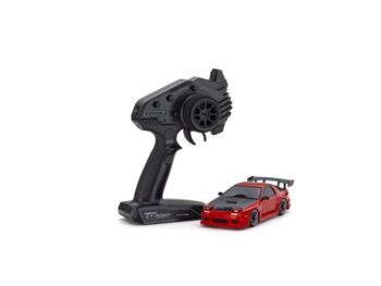 Op de foto staat een rode auto met zwarte details en een zwarte afstandsbediening. De auto heeft een spoiler en de afstandsbediening heeft het Kyosho logo.