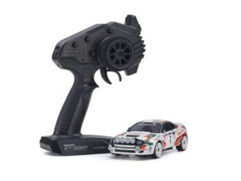 De foto toont een kleine modelauto met een bijbehorende afstandsbediening. De auto heeft een wit, rood en groen kleurenschema met stickers en details.