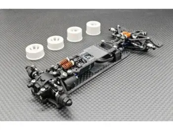 De foto toont een zwart chassis van een modelauto, met witte velgen en diverse andere componenten. De onderdelen zijn van metaal en kunststof.