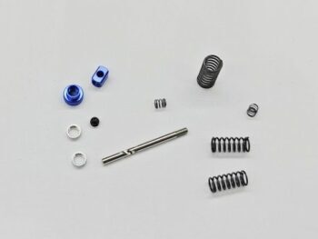 De foto toont verschillende onderdelen, waaronder veren, schroeven en andere kleine metalen componenten. De kleuren variëren van blauw en zilver tot zwart.
