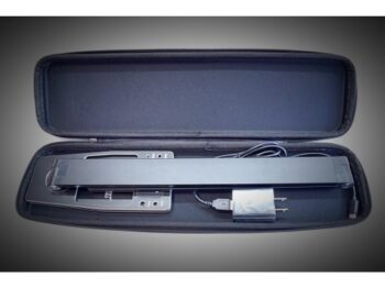 De foto toont een zwarte LED pit light in een zwarte hardcase. De pit light heeft een rechthoekige vorm en is opgevouwen in de koffer.