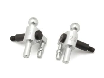 The photograph shows two silver-coloured steering blocks with black screws and black rubber seals. The blocks have a complex shape with multiple protrusions and a ball joint.