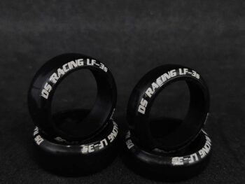 La photo montre quatre pneus noirs avec des lettres blanches. Les pneus sont ronds et ont un profil bas.