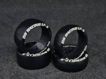 La photo montre quatre bandes noires avec des lettres blanches. Les bandes sont de forme ronde et sont faites d'un matériau semblable à du caoutchouc.