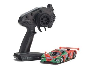 De foto toont een modelauto met een bijbehorende afstandsbediening. De auto heeft een rood, groen en wit kleurenschema.