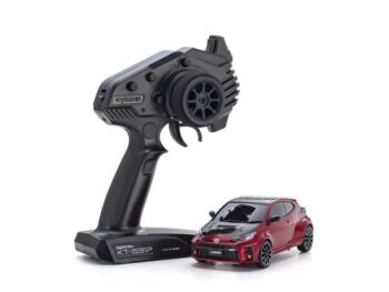 De foto toont een rode modelauto met een zwarte afwerking en een zwarte afstandsbediening. De auto heeft een sportief design en de afstandsbediening heeft een ergonomische vorm.