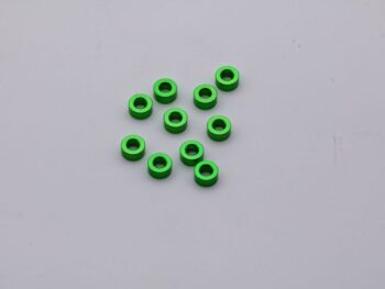De foto toont een aantal groene ringvormige onderdelen. Ze lijken van metaal te zijn gemaakt en hebben een gat in het midden.