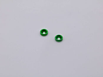 Op de foto zijn twee groene ringen te zien met een verzonken gat in het midden. De ringen liggen op een witte achtergrond.
