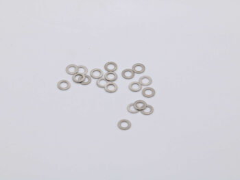 De foto toont een verzameling zilverkleurige ringen. De ringen zijn van metaal en liggen verspreid op een witte ondergrond.