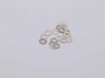 De foto toont een verzameling zilverkleurige ringen met een gat in het midden. Het lijken op shims van metaal.