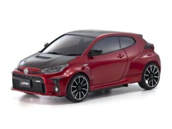 Das Foto zeigt ein rotes Modellauto, einen Toyota GRMN Yaris, mit schwarzer Motorhaube und schwarzen Akzenten. Das Auto hat schwarze Felgen und steht vor einem weißen Hintergrund.