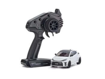 De foto toont een witte modelauto met een zwarte afwerking, samen met een zwarte afstandsbediening. De auto heeft een sportief ontwerp en de afstandsbediening heeft een ergonomische vorm.