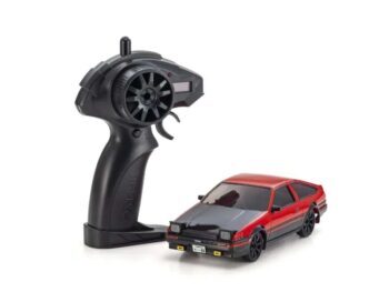 De foto toont een kleine rode en zwarte modelauto met een afstandsbediening. De auto heeft een herkenbare vorm en details.