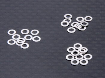De afbeelding toont een verzameling kleine, platte, ringvormige metalen onderdelen. Ze hebben een zilveren afwerking en lijken op shims.