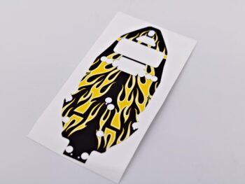 写真は、黄色い炎が描かれた黒いステッカーを示しています。ステッカーはシャーシの形に切り抜かれています。