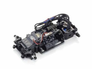 De afbeelding toont een zwart RC-autochassis met diverse elektronische componenten en bedrading. Het chassis is gedetailleerd met veren en mechanische onderdelen.