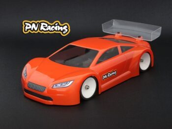 De foto toont een oranje gekleurde auto body kit voor een modelauto, met een transparante achtervleugel. Het product is gemaakt van lexaan en heeft stickers met het merk PN Racing.