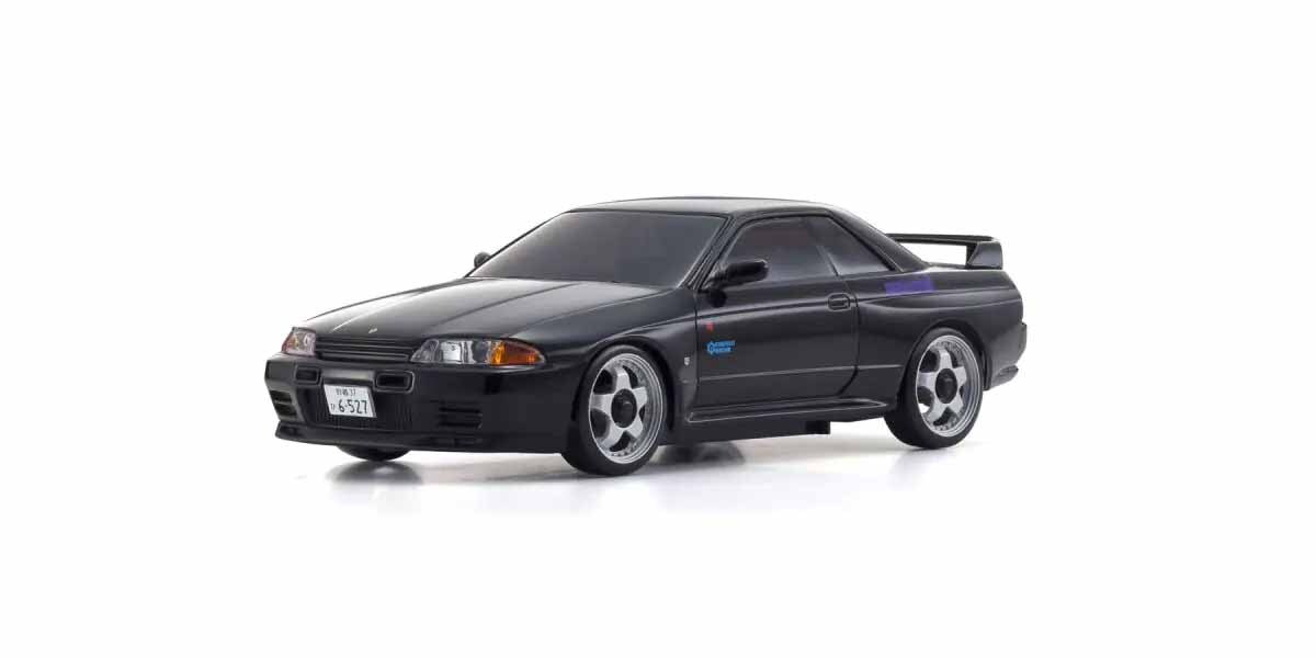 MZP482ID La photo montre une maquette de voiture noire, une Nissan Skyline R32. La voiture est équipée de jantes argentées et d'un aileron.