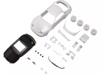 De foto toont een witte auto body set met verschillende onderdelen, waaronder een zwarte dak. De set bevat ook wielen en andere accessoires.