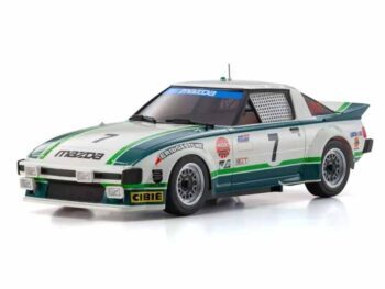 De foto toont een modelauto van een Mazda RX-7 in een race-uitvoering. De auto heeft een wit en groen kleurenschema met het nummer 7 erop.
