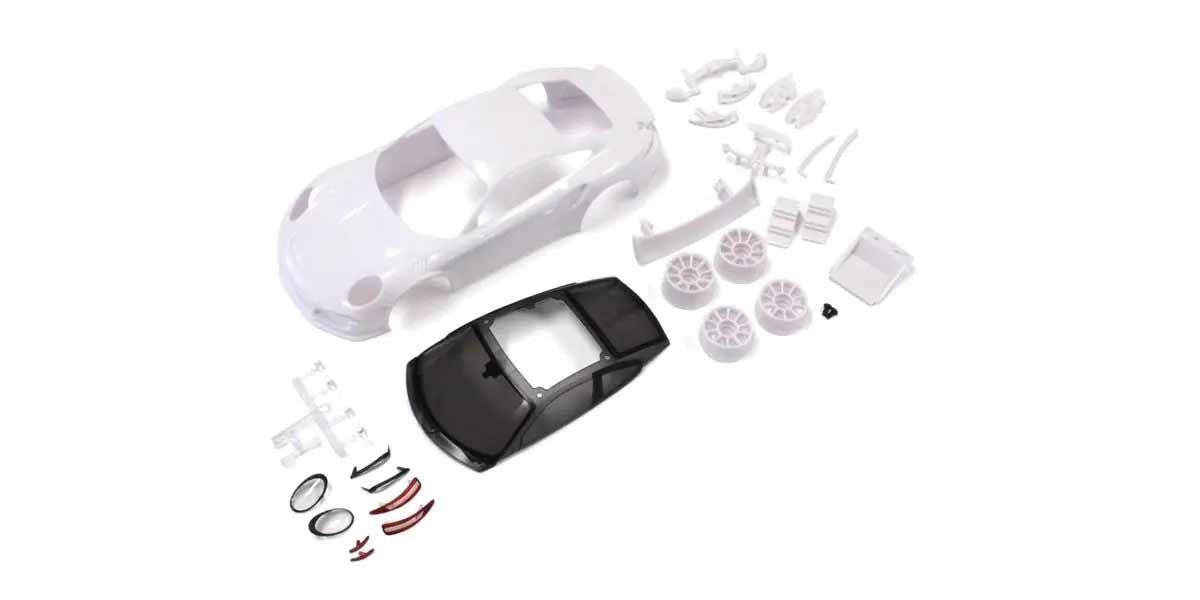 wit auto modelbouw kit onderdelen De foto toont een witte carrosserie van een auto, samen met andere onderdelen zoals wielen en spoilers. Er is ook een zwart dak aanwezig.