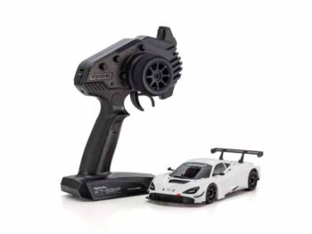 De foto toont een witte modelauto met een zwarte afstandsbediening. De auto heeft zwarte details en een achtervleugel.
