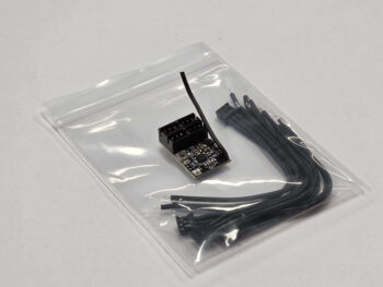 De afbeelding toont een kleine elektronische ontvanger met meerdere zwarte draden, verpakt in een doorzichtig plastic zakje. De ontvanger zelf is zwart met zichtbare componenten en een kleine antennedraad.