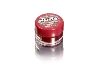 De afbeelding toont een klein potje met rode deksel en doorzichtig potje. Op de deksel staat de merknaam 'Hudy' en de productnaam 'Premium Bearing Grease'.