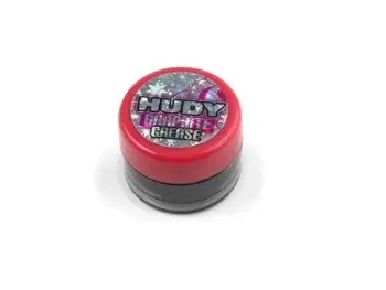 De foto toont een klein, rond potje met rode deksel en een donkergrijze basis. Op de deksel staat een logo met de tekst 'HUDY Graphite Grease'.