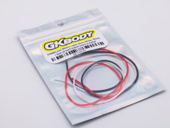 De foto toont een plastic zakje met daarin drie kabels in de kleuren rood, wit en zwart. Op het zakje staat een label met de merknaam en productinformatie.
