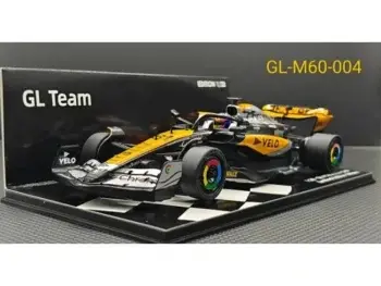 Das Foto zeigt ein Modell eines Formel-1-Rennwagens in Schwarz und Orange. Der Wagen steht auf einem schwarz-weiß karierten Sockel.