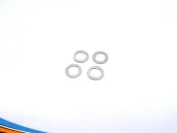 De foto toont vier zilverkleurige ringen, vermoedelijk flenzen. Ze liggen verspreid op een witte achtergrond.