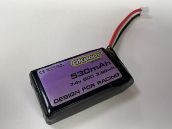 De afbeelding toont een zwarte LiPo batterij met een paars label. Op het label staat "GKBODY", "530mAh", "7.4v 60C 3.92wh" en "DESIGN FOR RACING". Er is ook een witte connector met rode, zwarte en witte draden zichtbaar.