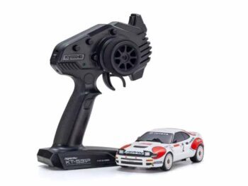 De foto toont een kleine modelauto met een bijbehorende afstandsbediening. De auto is wit met rode en zwarte accenten en de afstandsbediening is zwart.