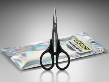Zwarte GKBODY GK30008 rechte schaartool met metalen lemmet, liggend op een glanzende, iriserende verpakking.