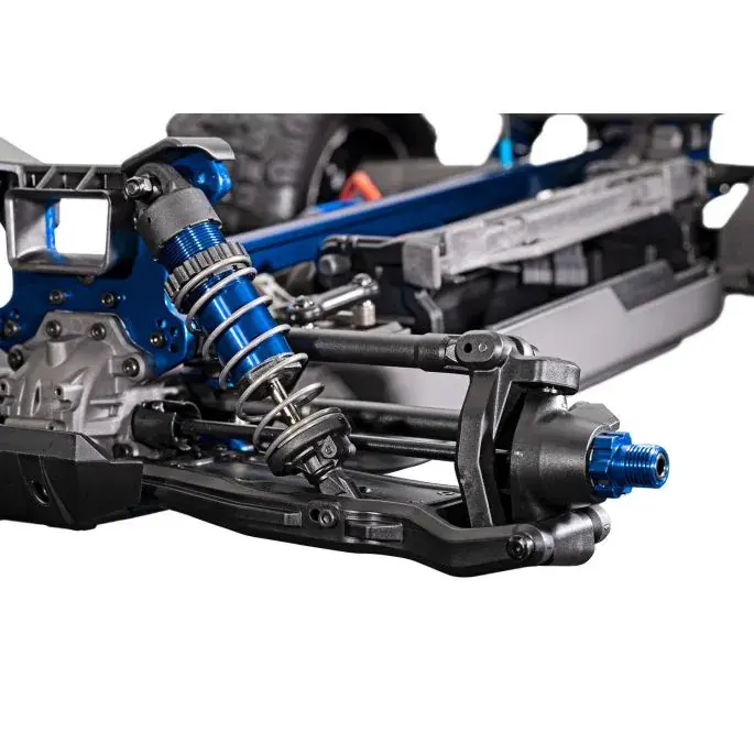 Gedetailleerd beeld van de blauwe schokdempers en ophanging van de Traxxas Sledge RC auto.