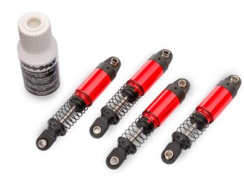 Vier rode Traxxas schokdempers voor een RC-auto naast een flesje siliconen schokdemperolie.